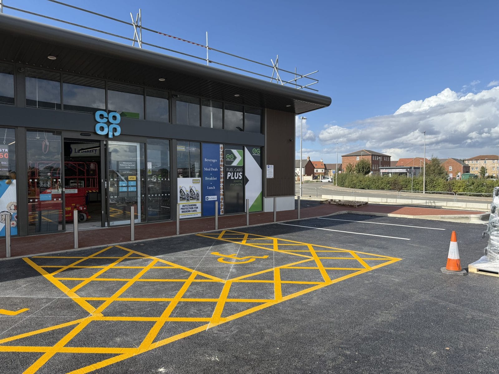 Commercial building with large glass windows and freshly painted yellow parking lot markings.