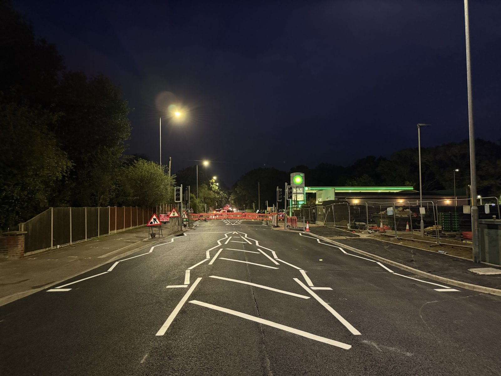 Night view of a road with white painted traffic lines and road markings.